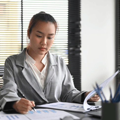 A translator proofreads an engineering report for Chinese Translation Services in Houston, verifying measurements & diagrams.